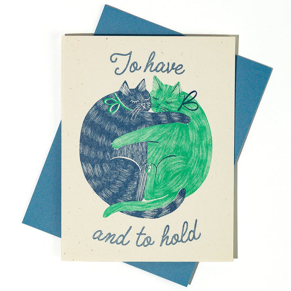 Card with illustration of two cats hugging and text 'To have and to hold' on a blue envelope.