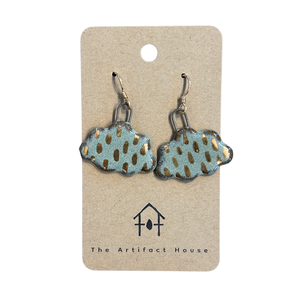Pair of storm cloud earrings on a 'The Artifact House' branded card against a white background