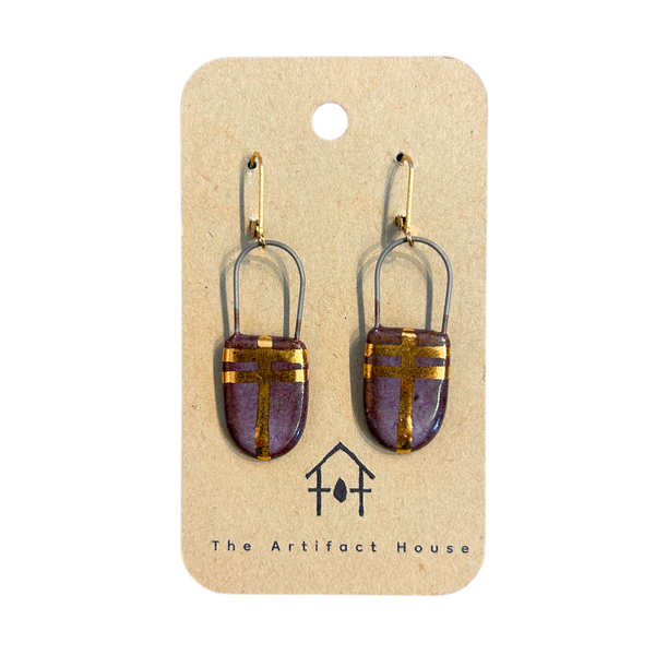 Pair of eggplant and gold earrings on a 'The Artifact House' branded card against a white background