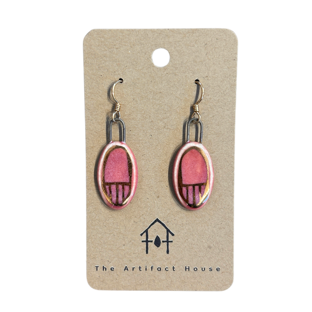 Pair of pink and gold ceramic earrings on a 'The Artifact House' branded card.
