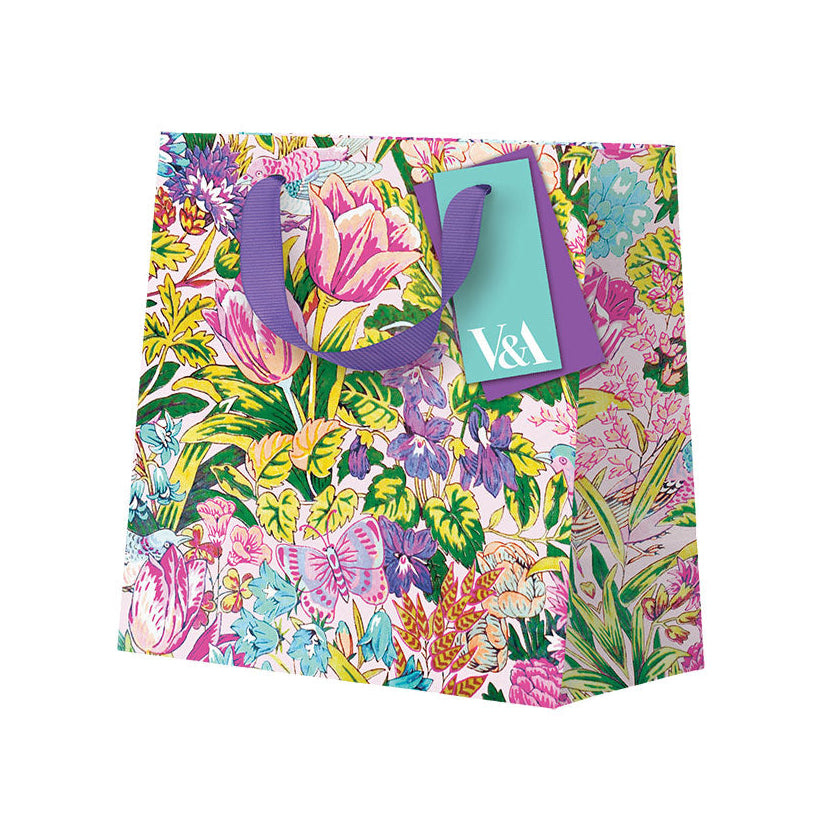 Floral-patterned gift bag with a purple handle on a white background