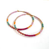Colorful beaded hoop earrings on a white background