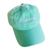 Mint green cap with 'tchatchkes' embroidery on a textured surface