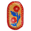 An oval ceramic serving tray with a speckled beige base, decorated with two red poppy flowers, blue leaves, and a red patterned rim, shown on a plain white background.